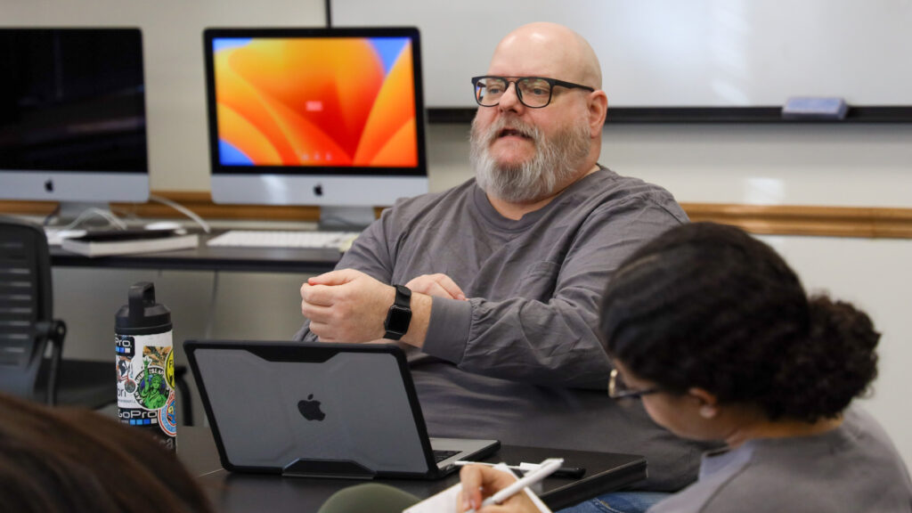 Man sitting down teaching class