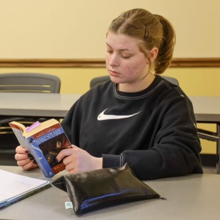 Woman reading book in classroom