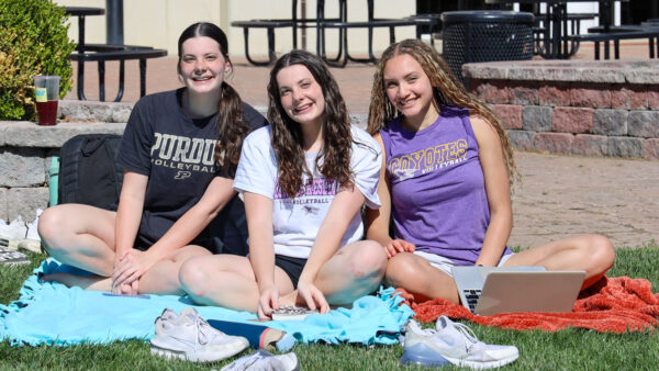 Three women sitting on lawn