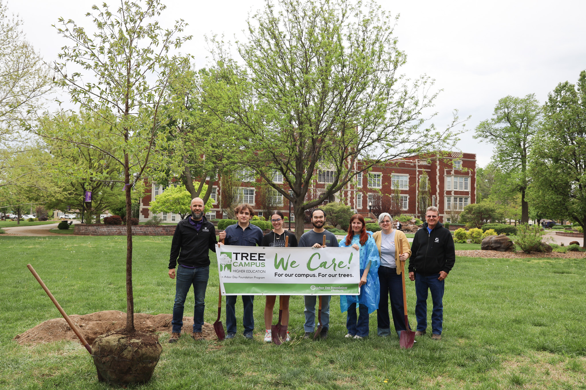 Group of people holding sign about trees