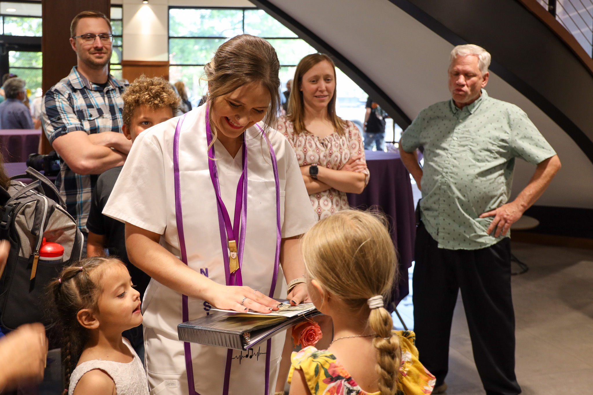 Nursing graduate receiving gift from family