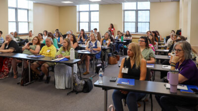 Group of people sitting in chairs in classroom
