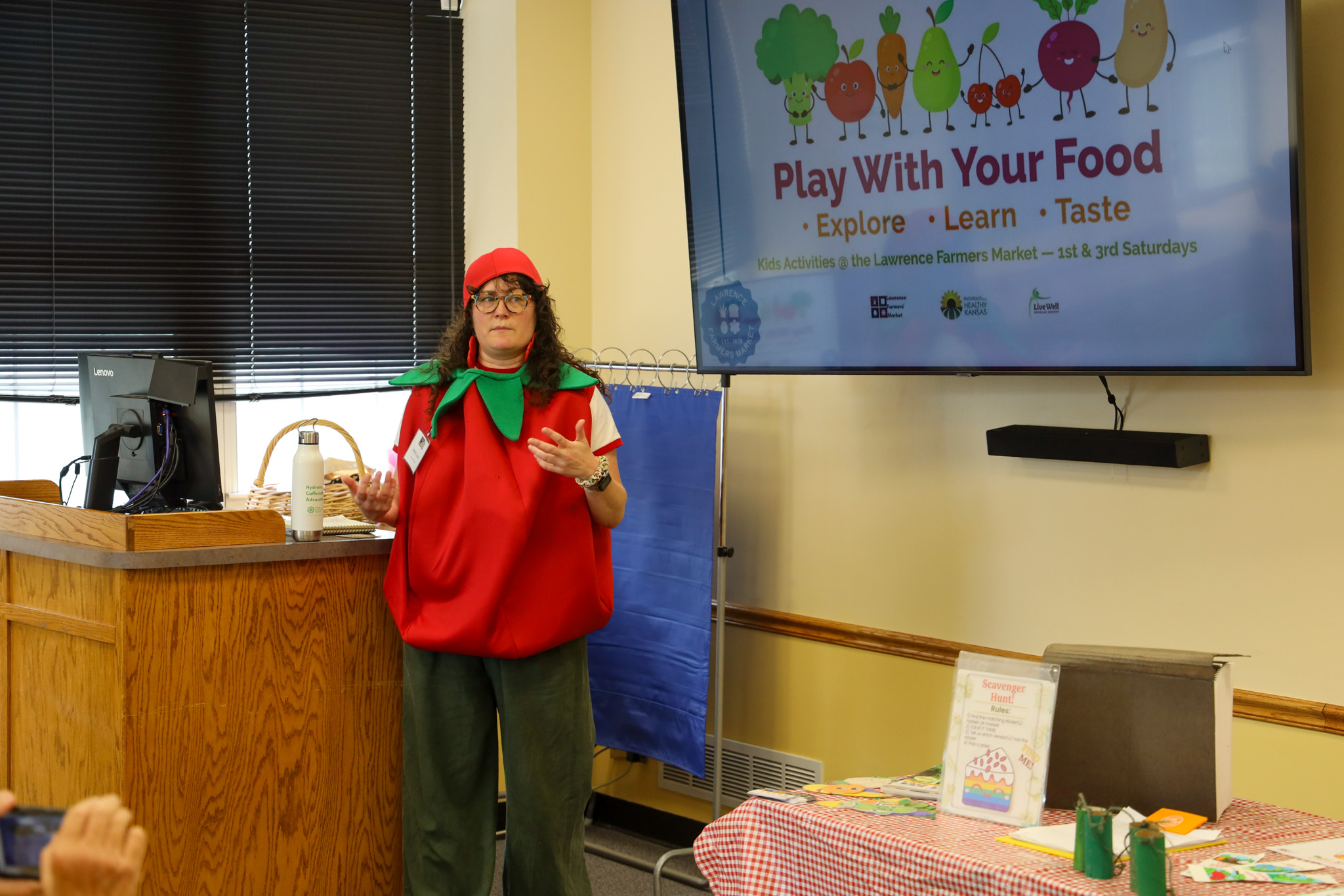 Woman dressed as apple presenting in classroom