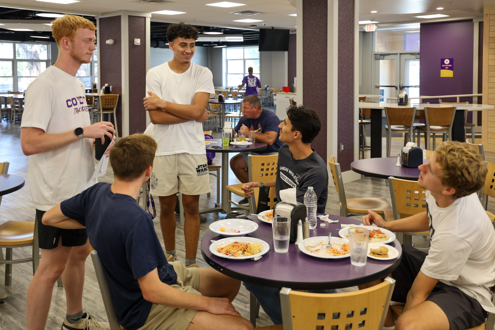 People in dining hall gathered around table