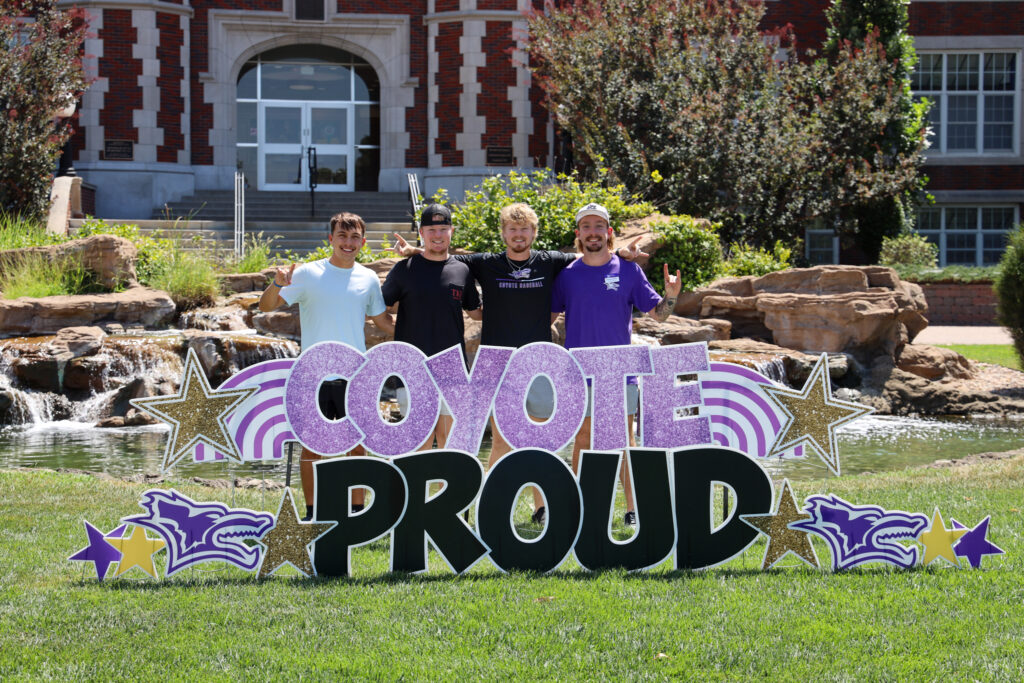 Group of people gathered behind KWU sign