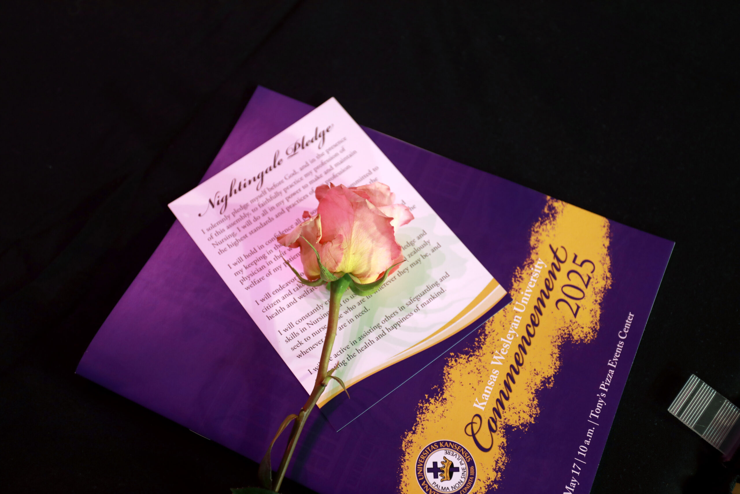 Rose on top of card and book