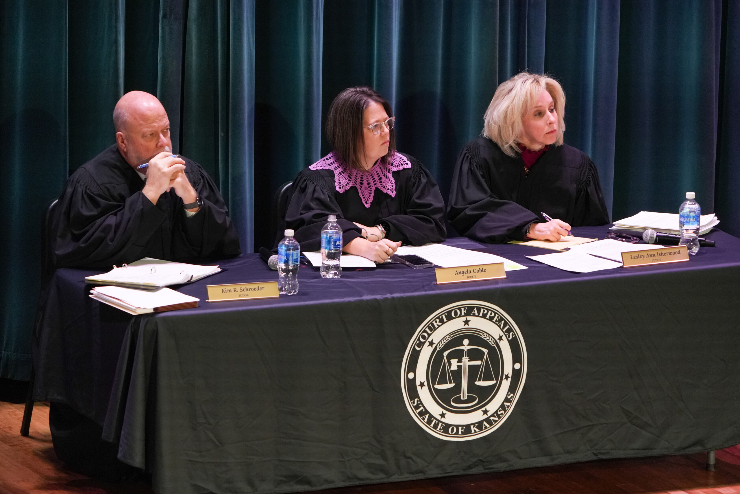 Three judges in robes at table