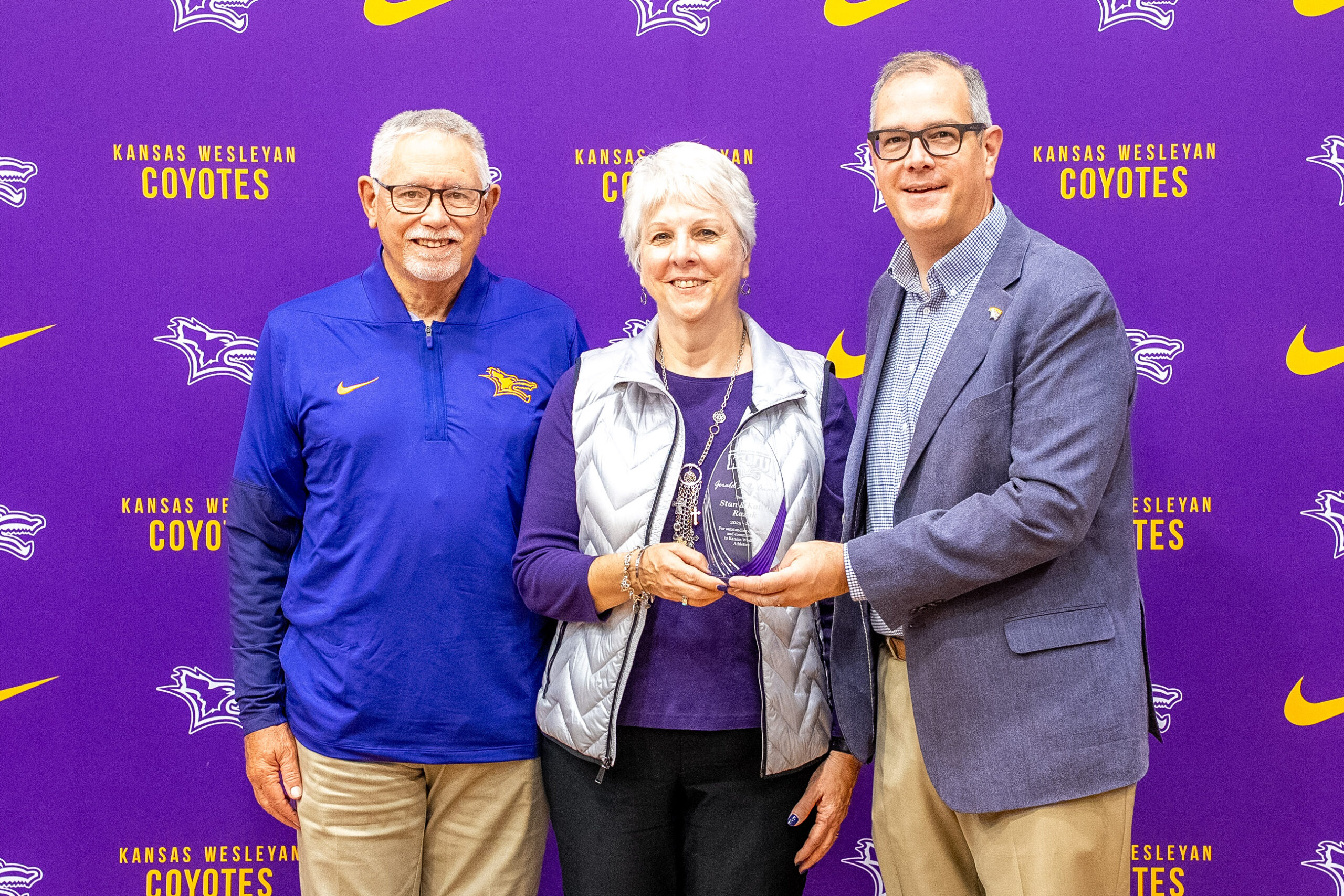 Man presenting award to couple