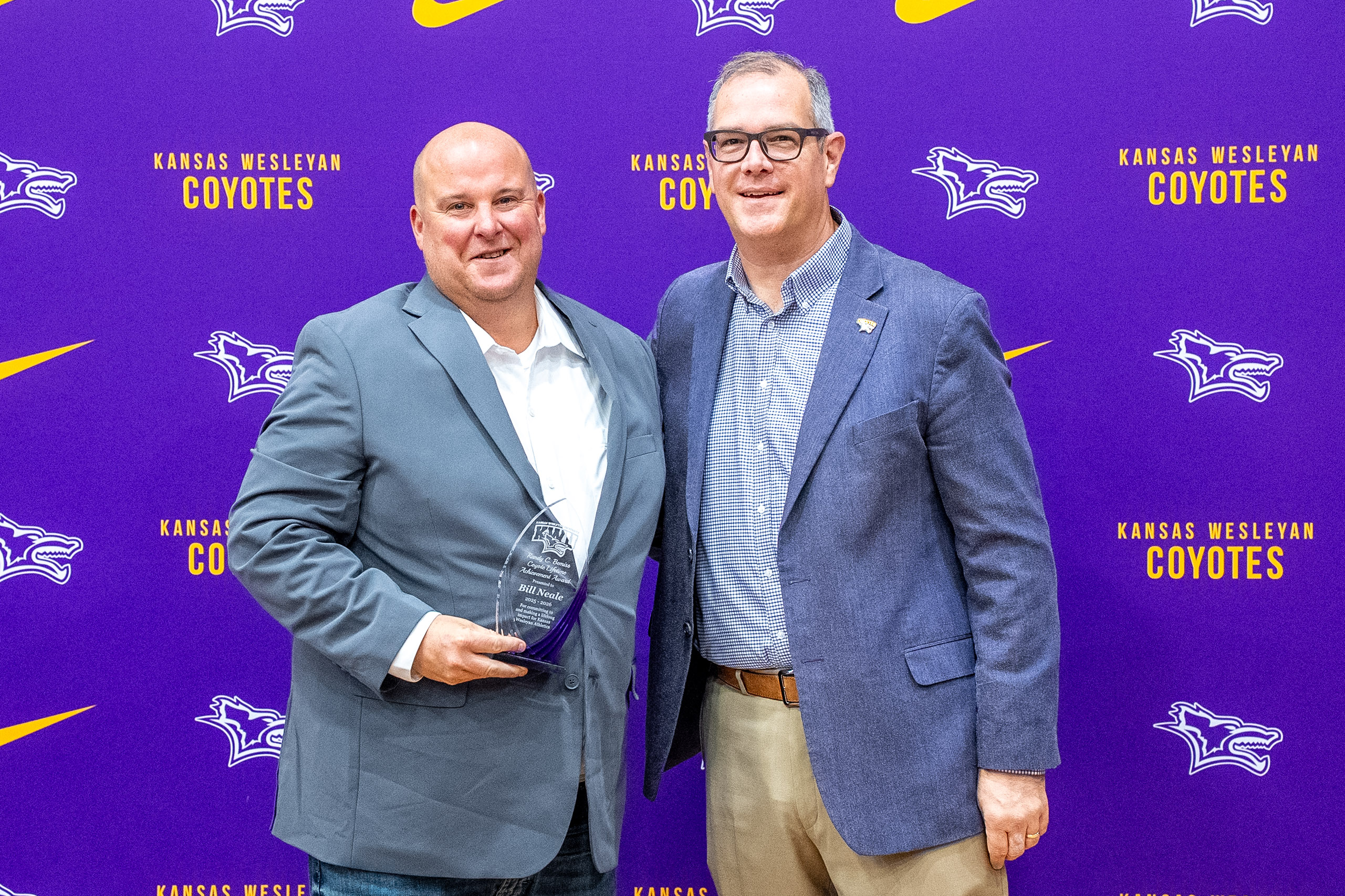 Man presenting award to other man