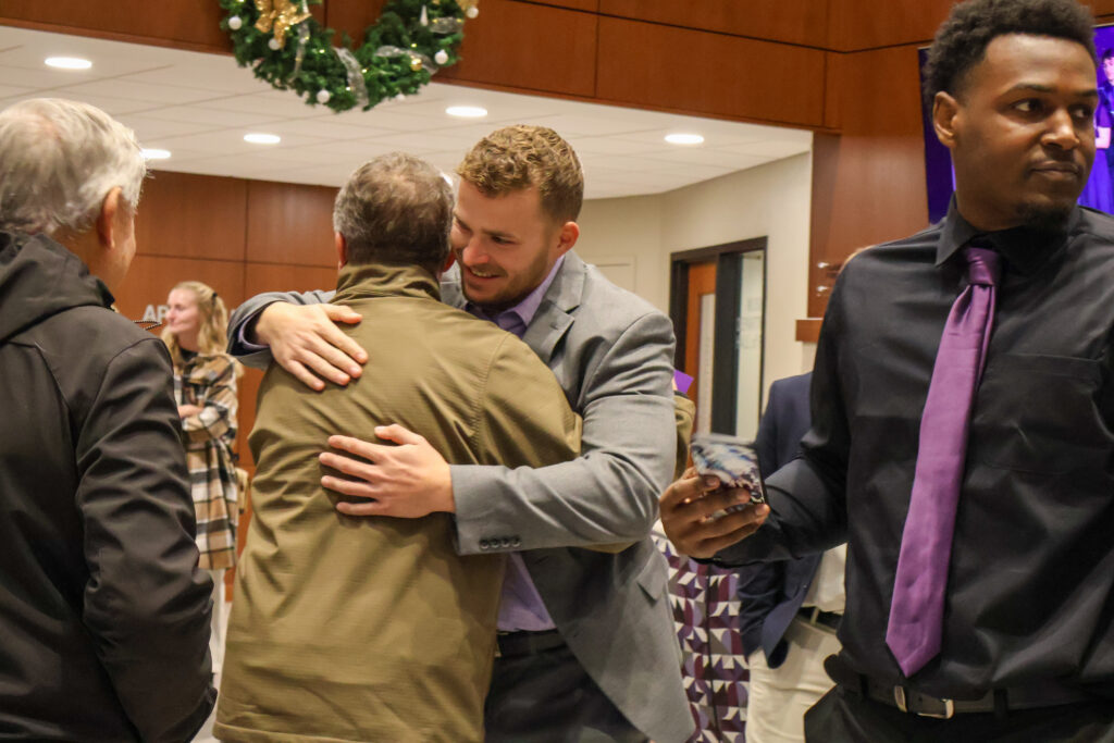 Graduate hugging other person