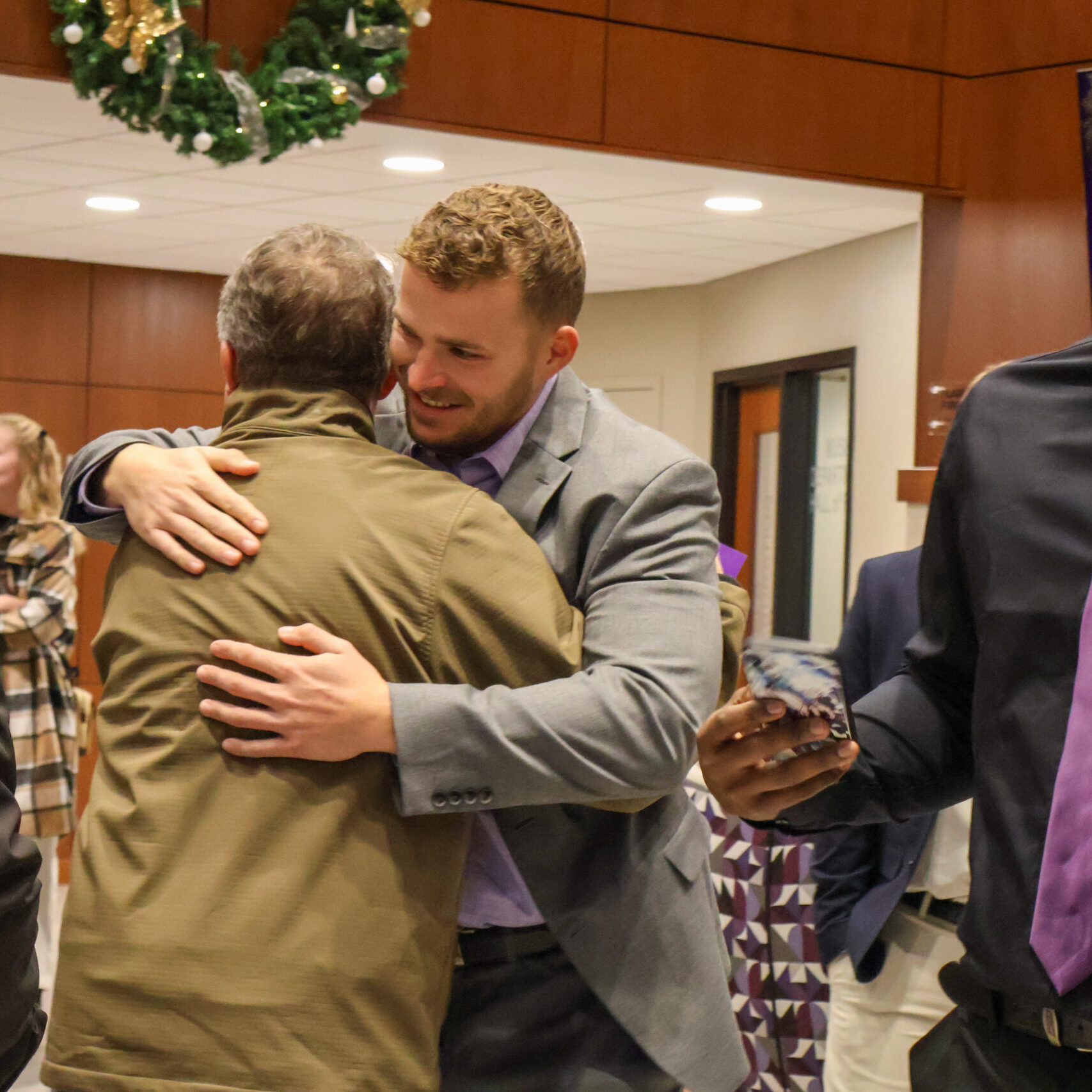 Graduate hugging other person