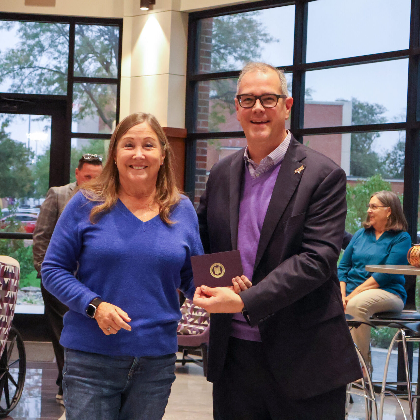 Man standing by woman with award