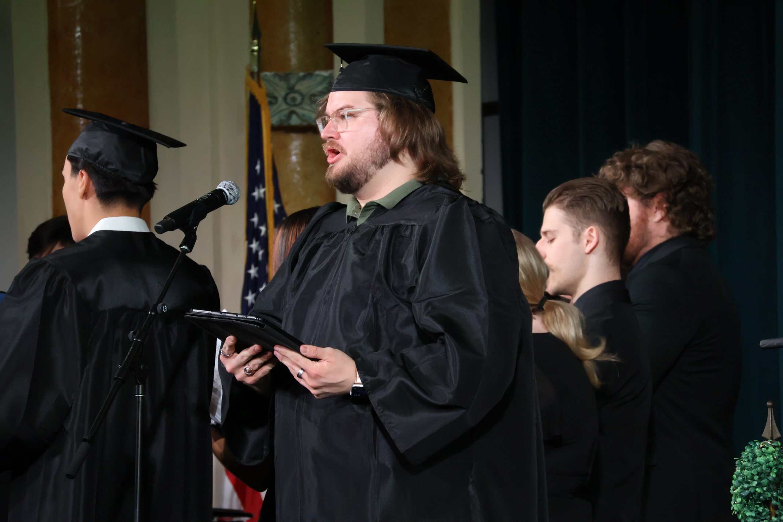 Man in cap and gown singing