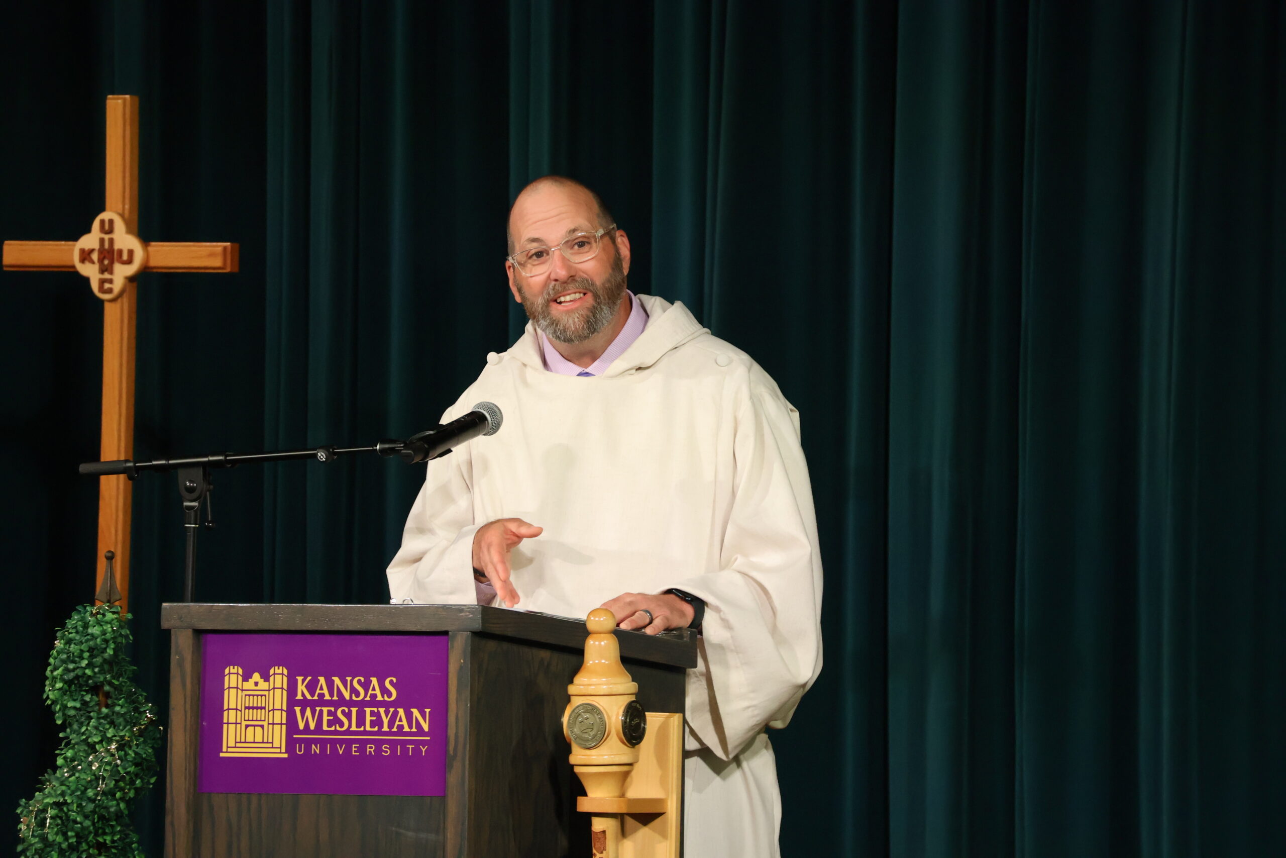 Man in clergy robes speaking at podium