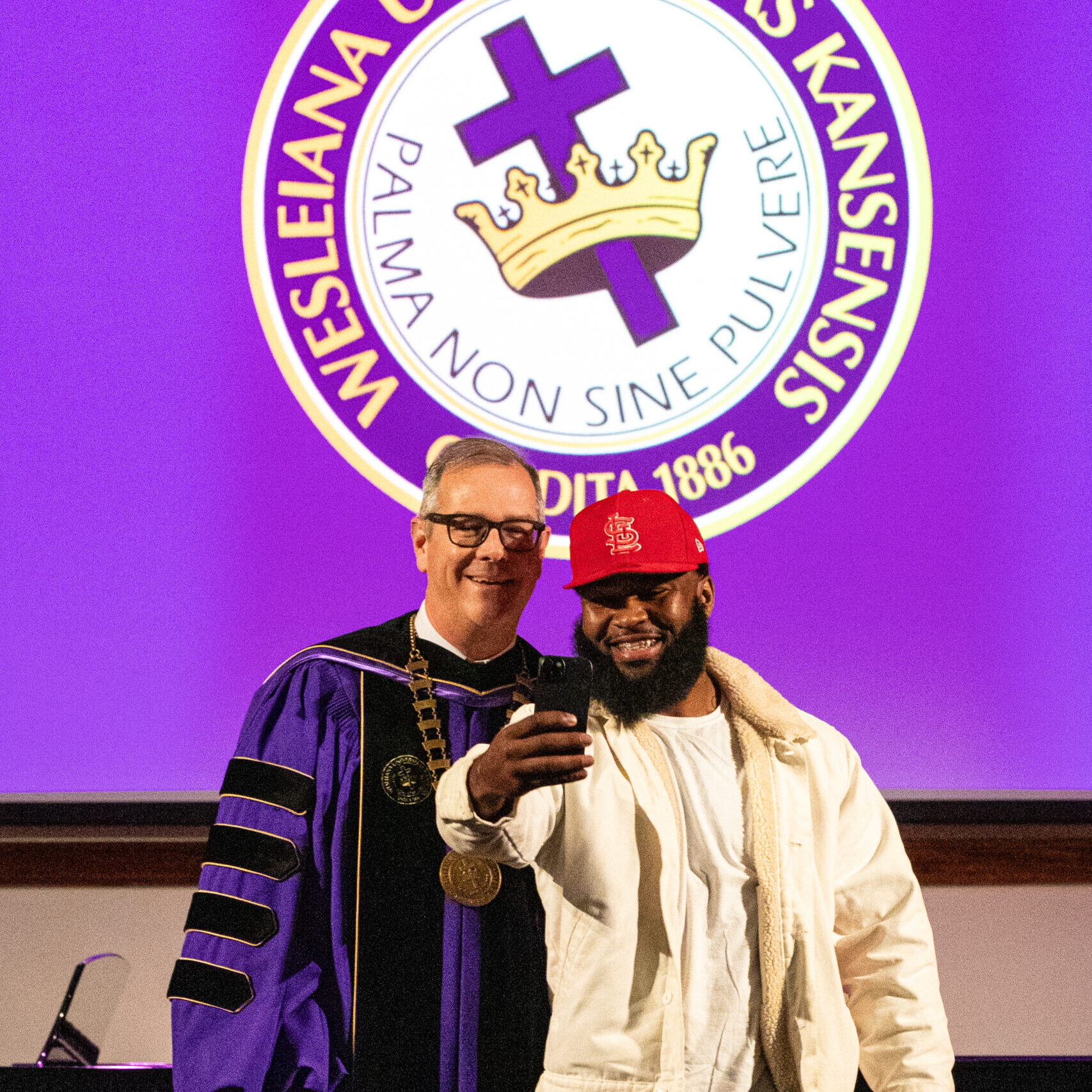 Male graduate doing selfie with president