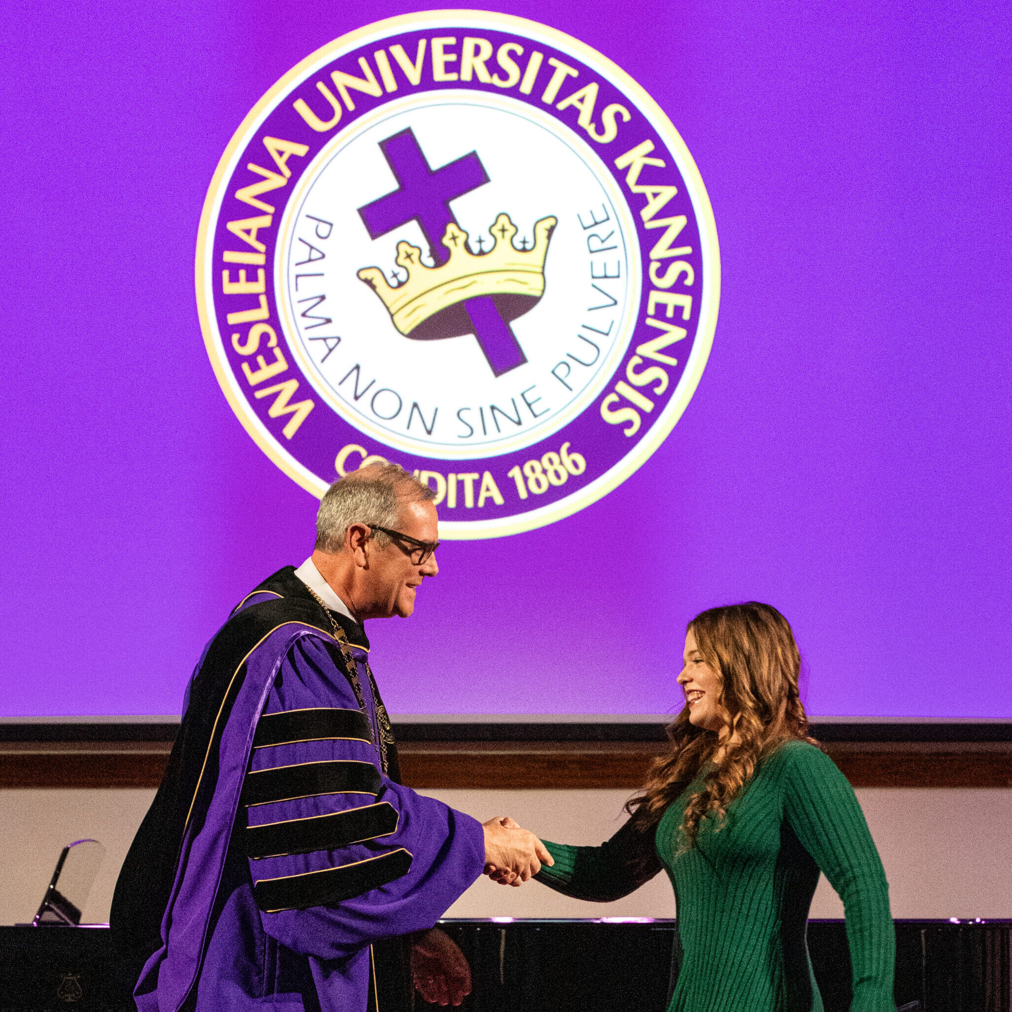 Female graduate shaking hands with president