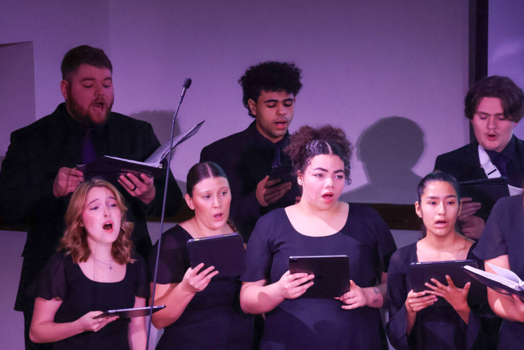 Group of people singing in concert dress