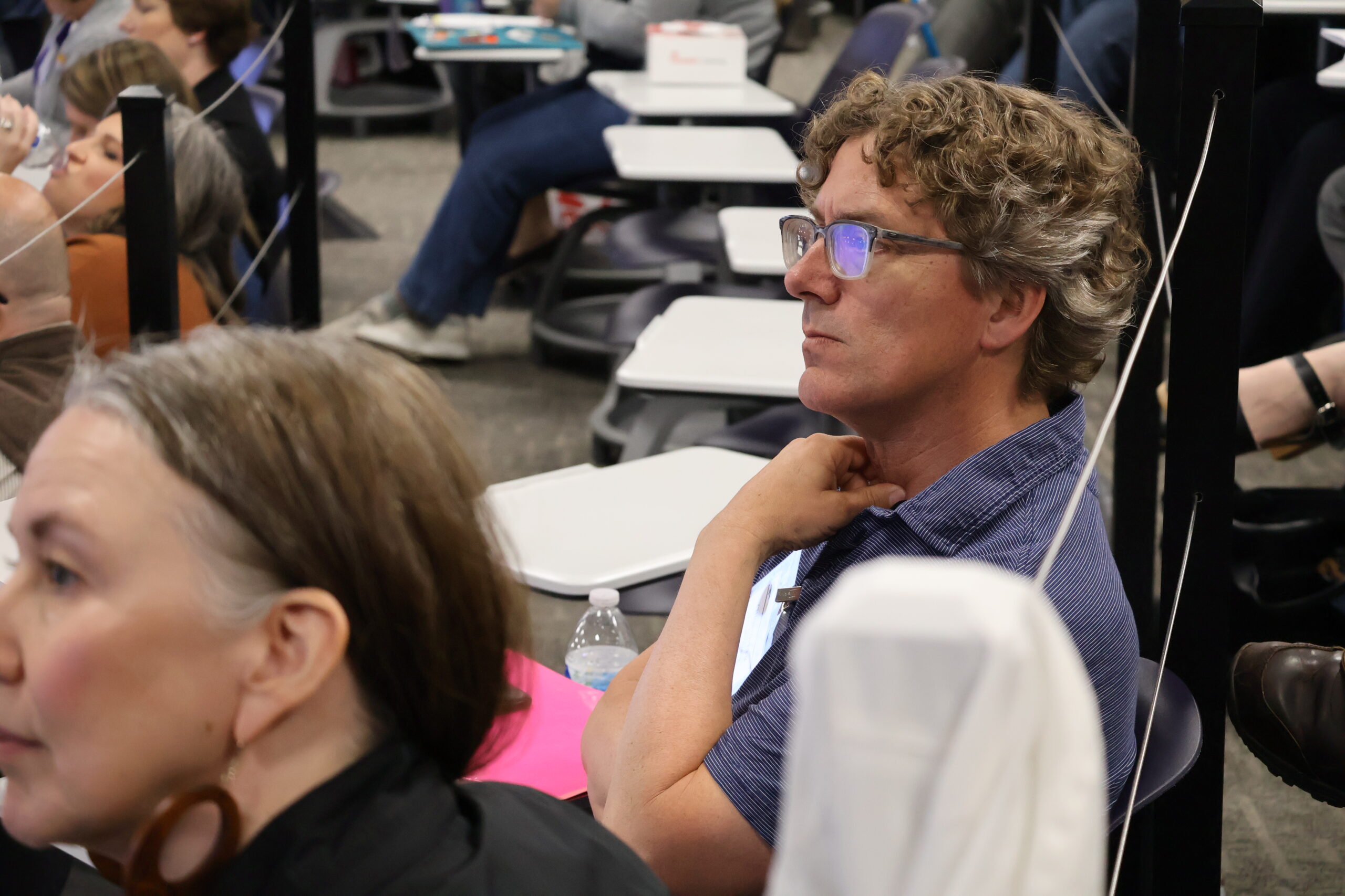 Man sitting in chair listening to speaker
