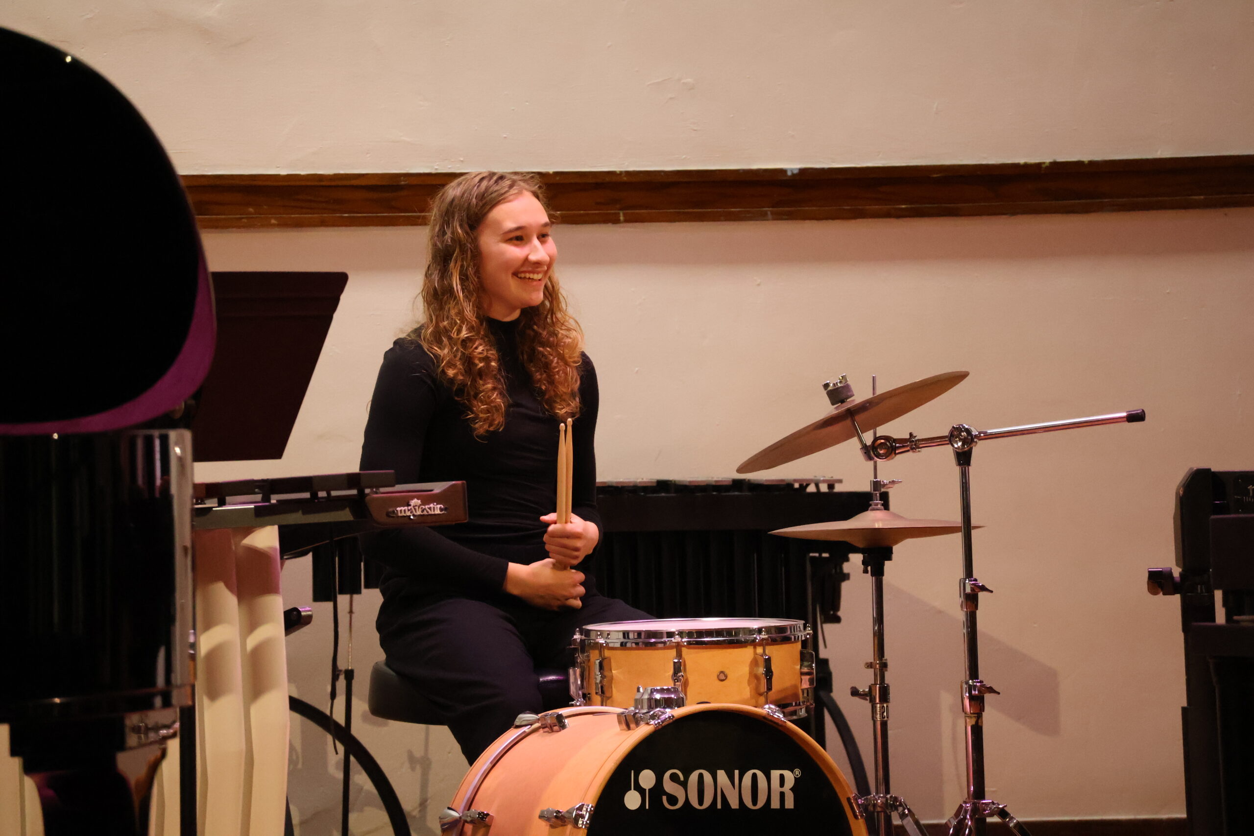 Woman sitting behind drum set