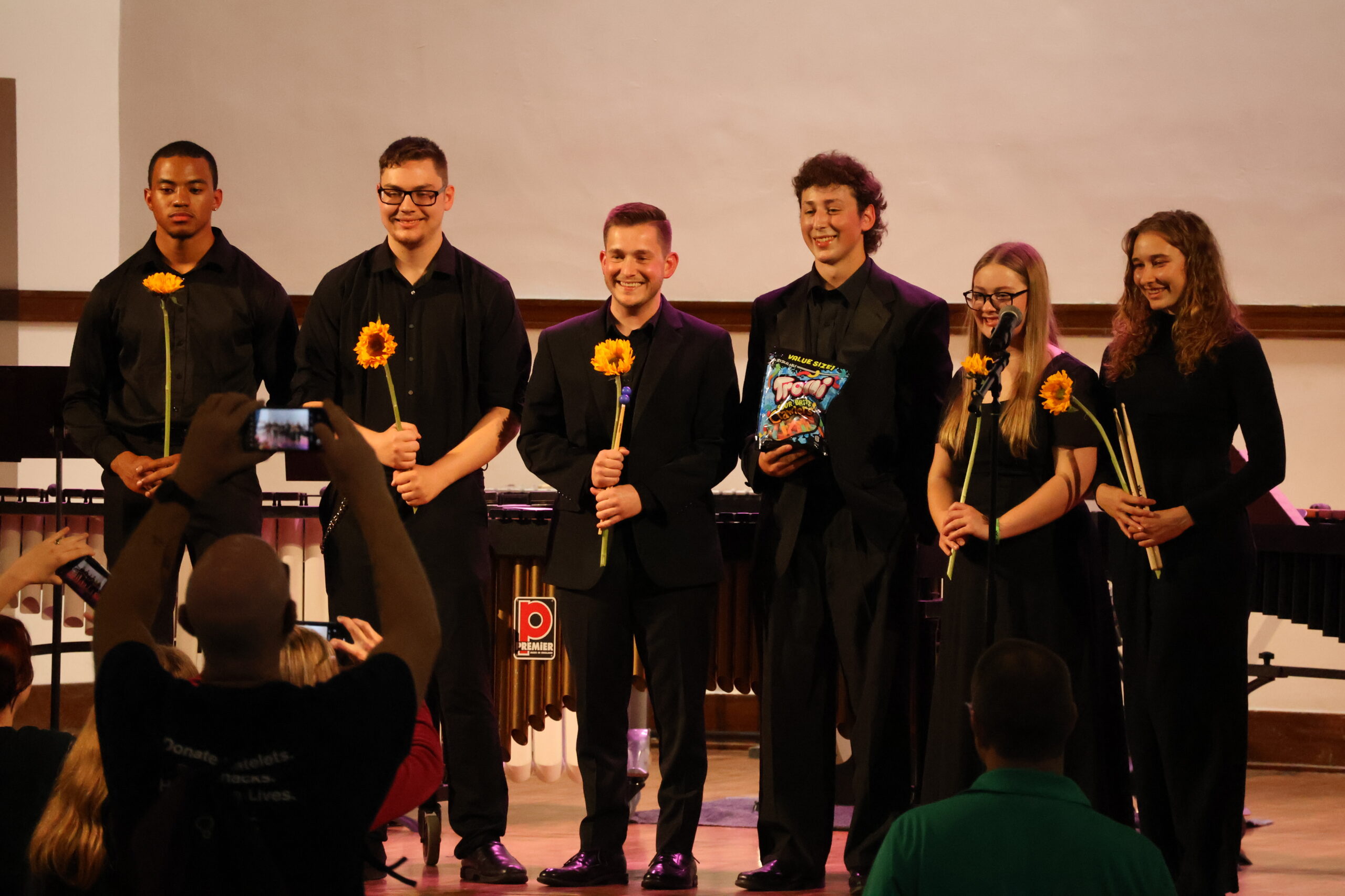Percussion ensemble group together on stage