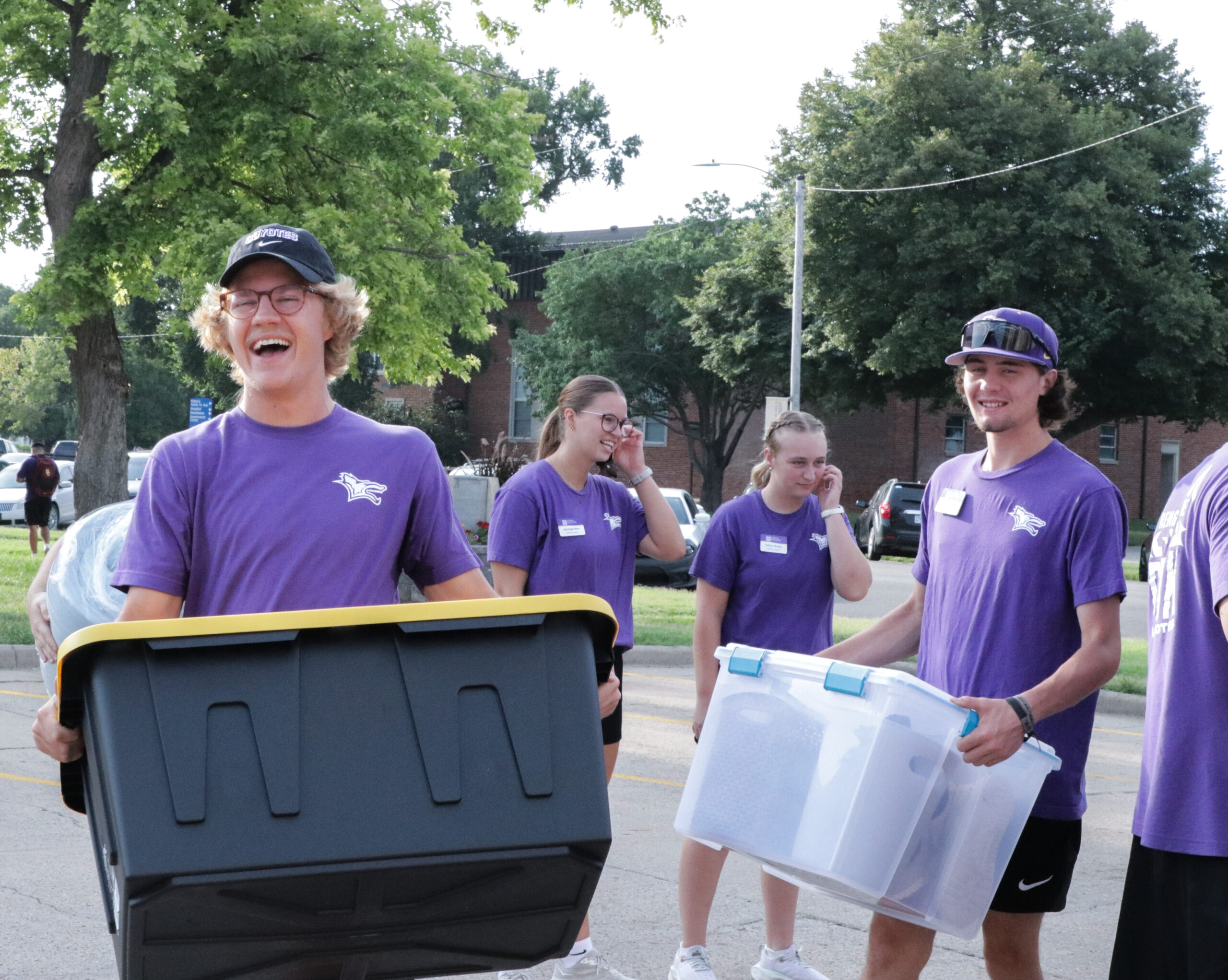 Male student carrying box during move i