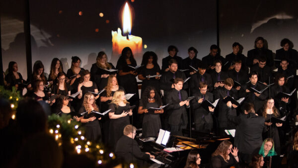 Large vocal group with candle in background