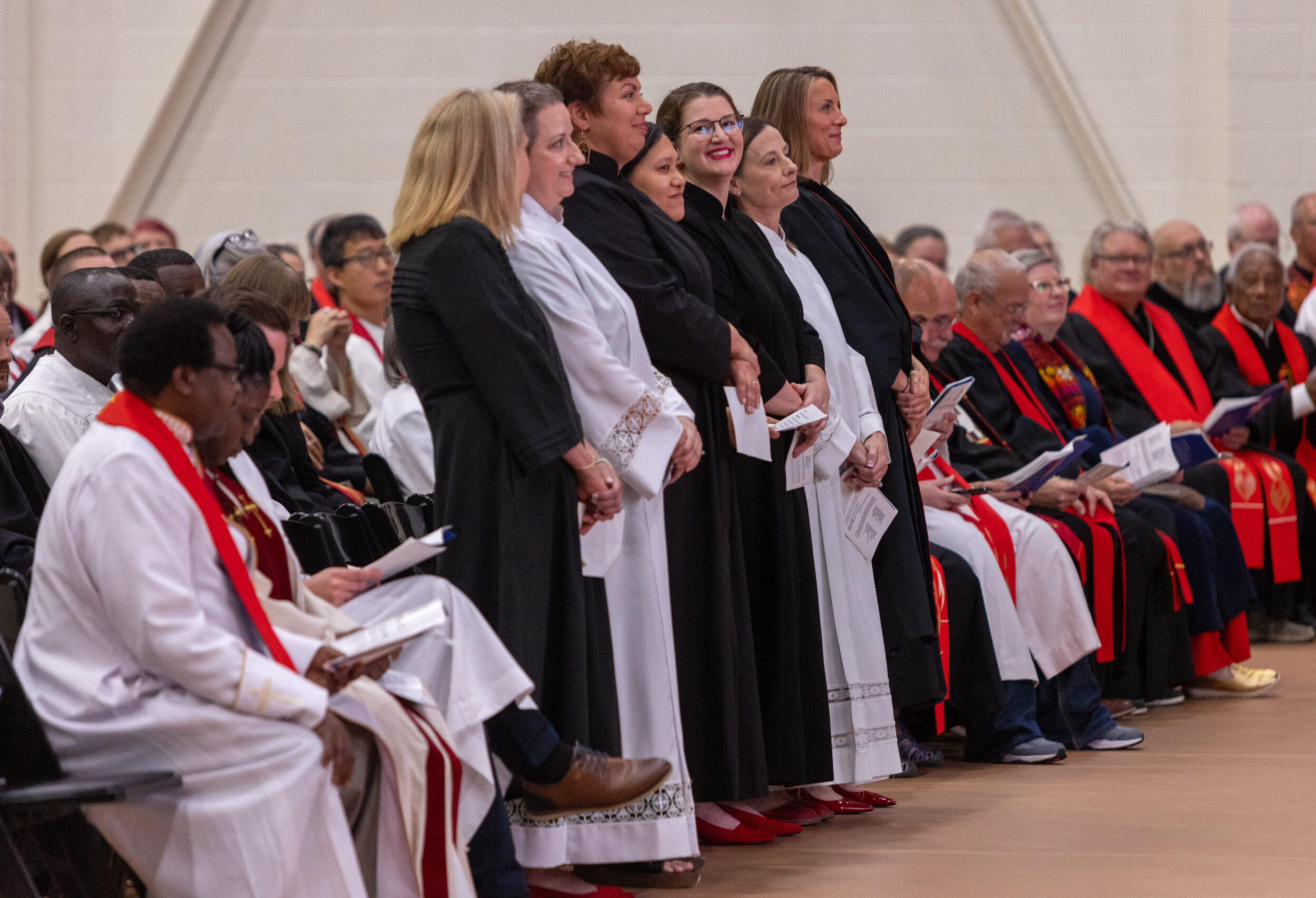 Group of women standing during service, in clergy robes