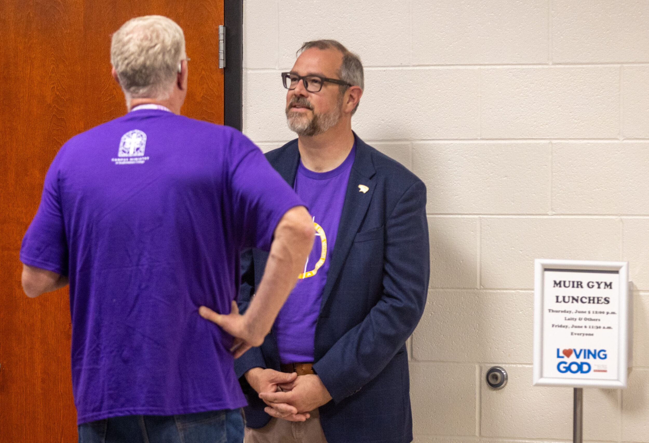 Man talking to another in hallway