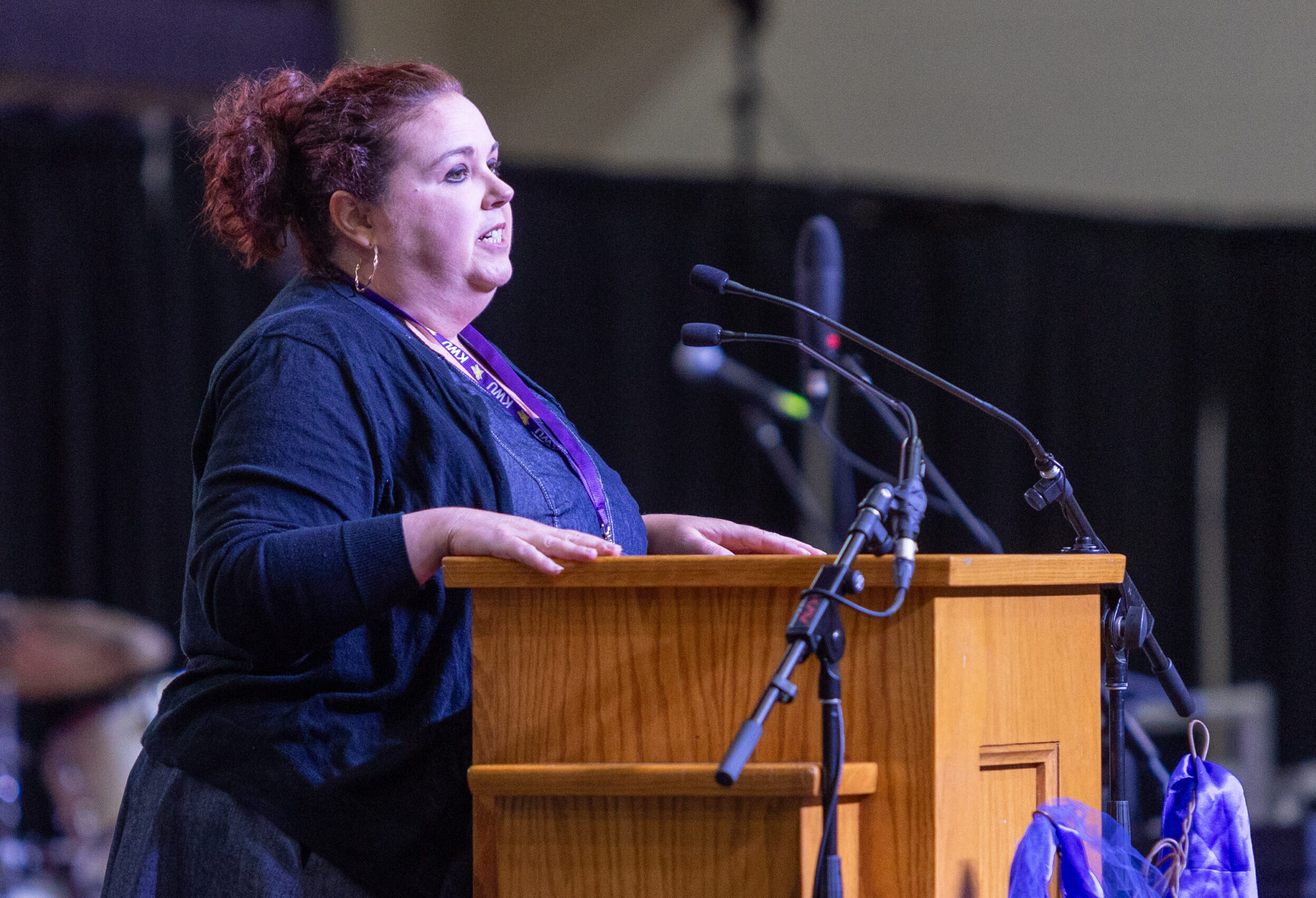 Woman speaking from platform on stage
