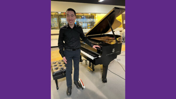 Man standing next to Piano